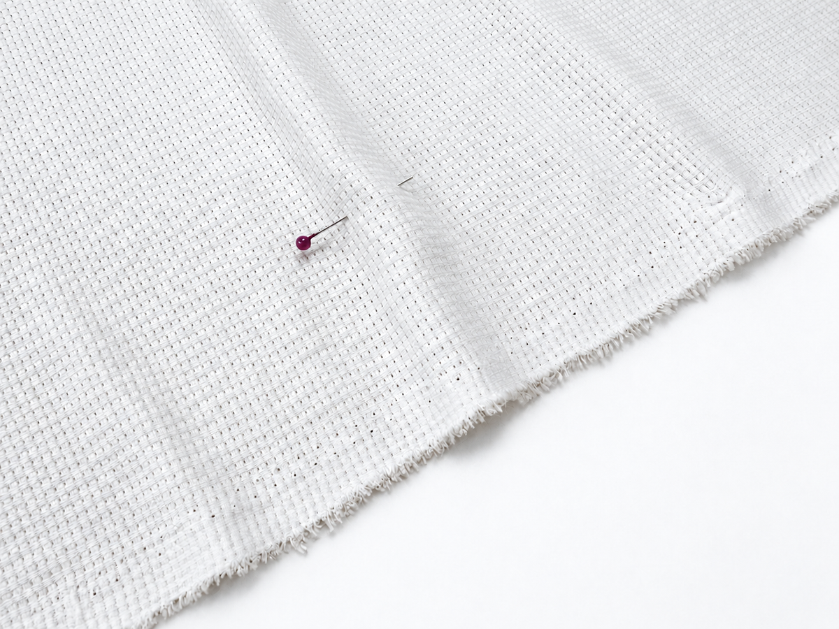 Single poly waffle knit fabric texture in a neutral white and gray weave